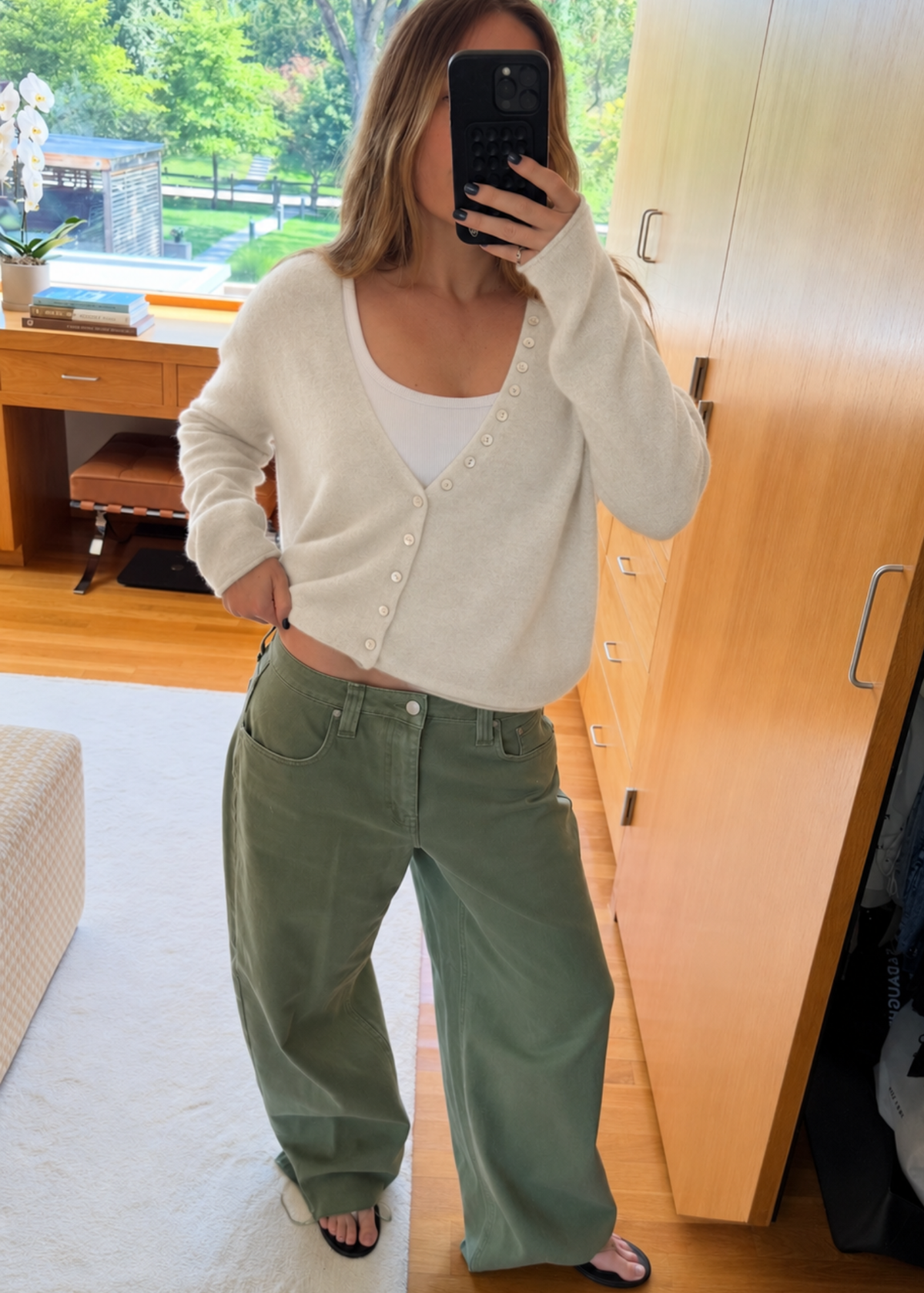 ivory cashmere sweater with pearl buttons and green lowrise jeans.