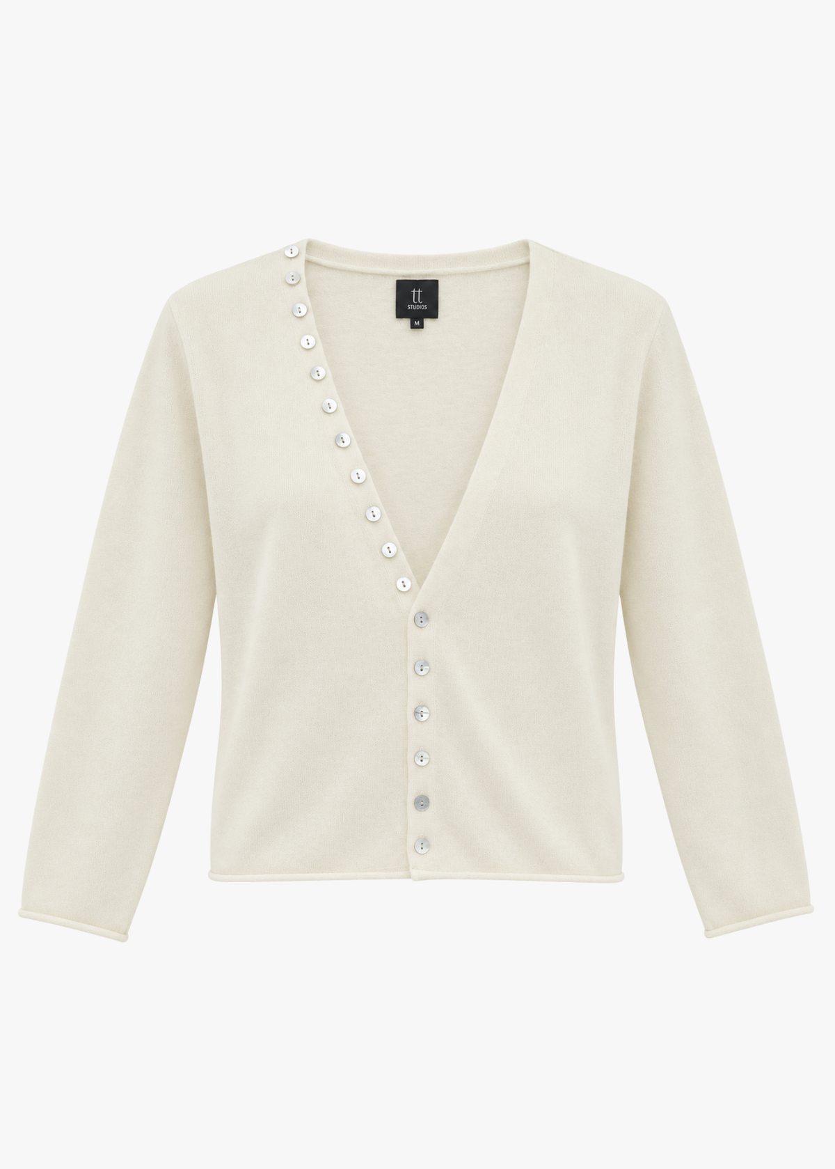 ivory cashmere sweater with pearl buttons on a light background