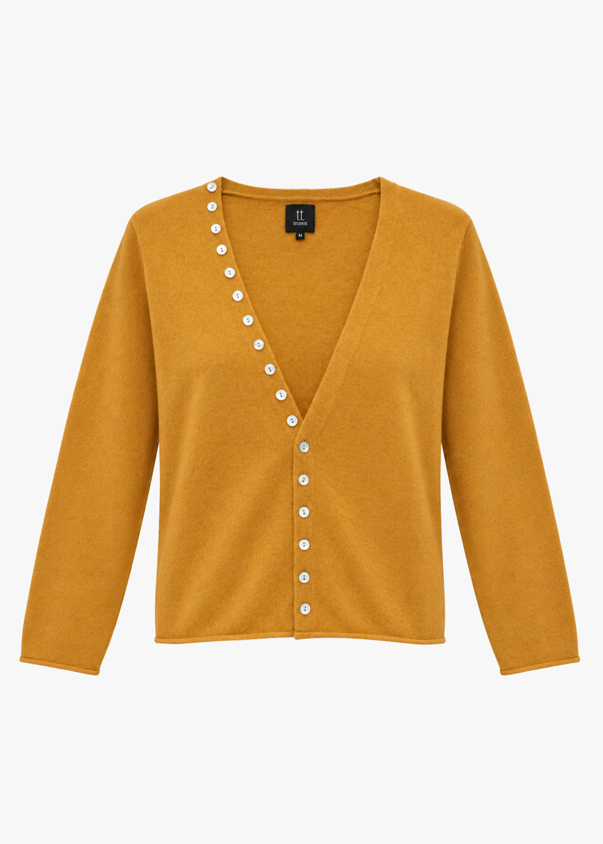 tumeric orange cashmere sweater with pearl buttons on a light background
